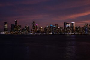 Skyline illuminato di Jersey City al tramonto riflesso sulle acque del fiume Hudson